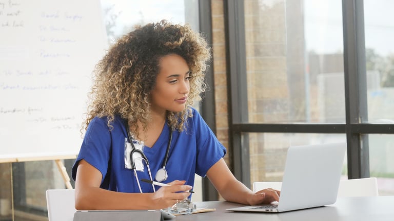 Young nurse uses laptop for research